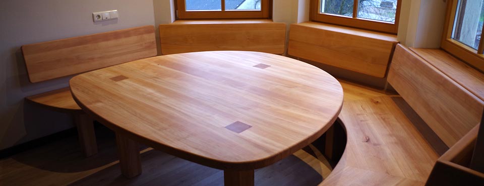Geschwungene Sitzbank mit rundem Tisch